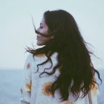 Confident Mormon woman by seaside.