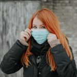 girl holding up medical mask